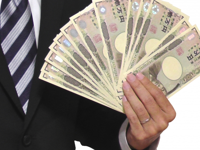 1万円札を広げる男性